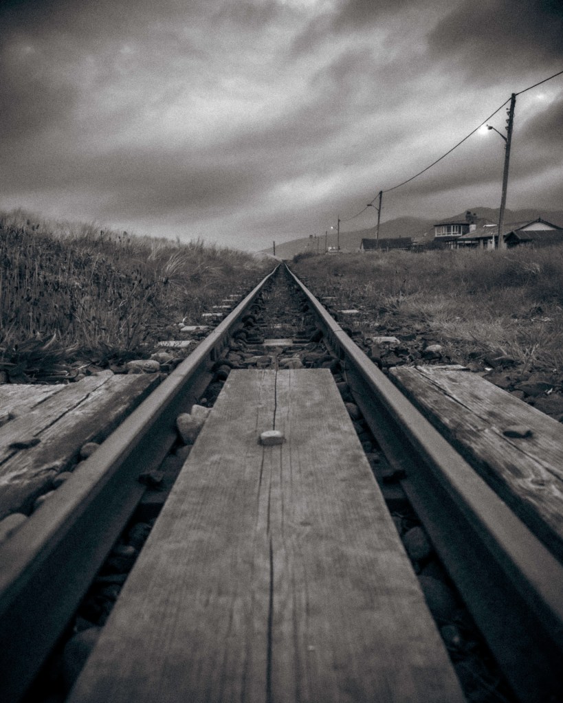My photograph of the tracks running into the distance in the Blue Hour with moody skies - Fairbourne Railway in Eryri National Park